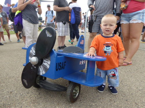 Showing off his ride.. This tyke attending the EAA AirVenture Oshkosh may have a bright future in the aviation industry_ Harriet Baskas