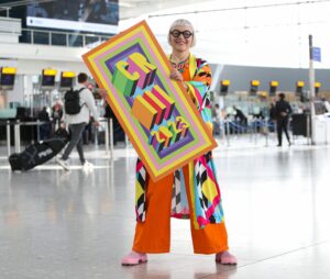 EDITORIAL USE ONLY

Artist Morag Myerscough unveils HeathrowÕs commemorative luggage tag that she designed to celebrate King Charles IIIÕs coronation, to be given out to passengers from May 1-10. Issue date: Monday April 24, 2023. PA Photo. The airport is preparing to welcome passengers on board 12,000 flights in the 10 days around the coronation, including dignitaries, heads of state and international tourists, with the same number of souvenir tags being released to mark the occasion. Photo credit should read: Kieran Cleeves/PA Wire.